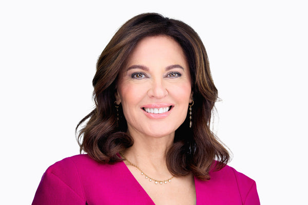 Dr. Doris Day, board-certified dermatologist, smiling in a magenta top